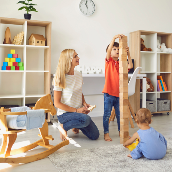 An image of a mom and children playing wooden building blocks.