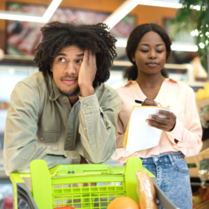 Unhappy Black Couple Counting Prices In Shopping List In Supermarket