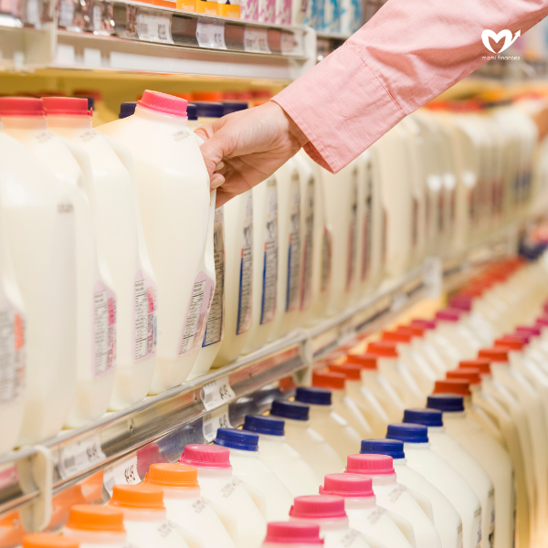 Woman selecting milk from dairy aisle in supermarket